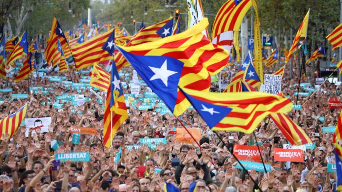 People wave separatist Catalan flags and placards during a demonstration organised by Catalan pro-independence movements ANC (Catalan National Assembly) and Omnium Cutural, following the imprisonment of their two leaders in Barcelona